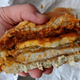 hand holding cut chicken sandwich